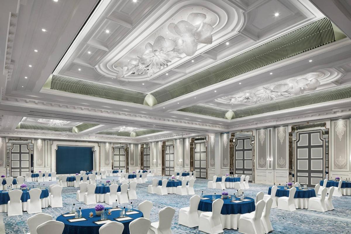 a ballroom with tables and chairs and a coffered ceiling at The Ritz-Carlton, Pune in Pune