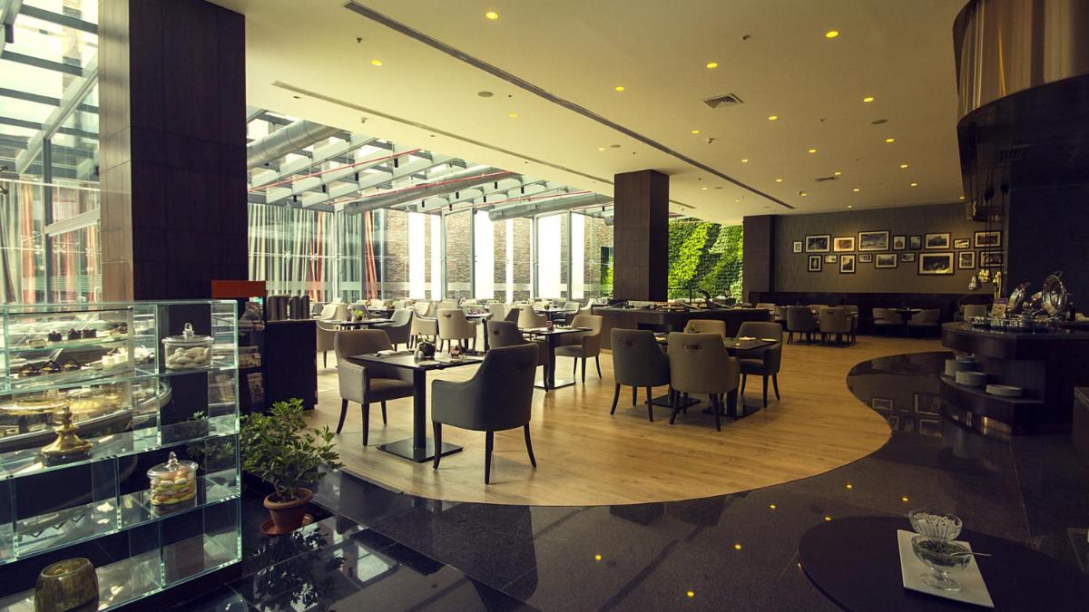 a restaurant with tables and chairs in a building at The Oterra in Bengaluru