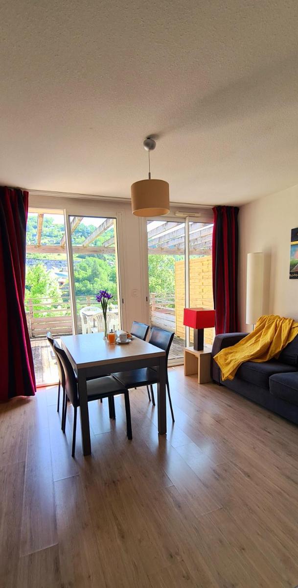 un salon avec une table et un canapé dans l'établissement Résidence Goélia Les Gorges de la Truyère, à Entraygues-sur-Truyère