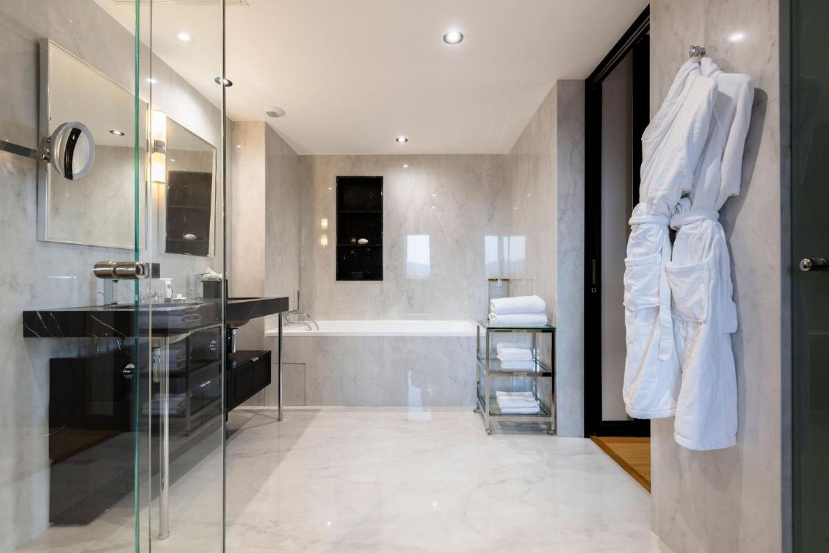 une salle de bain avec une baignoire et un lavabo dans l'établissement Hôtel Restaurant le Touring - Teritoria, à Saint-Raphaël