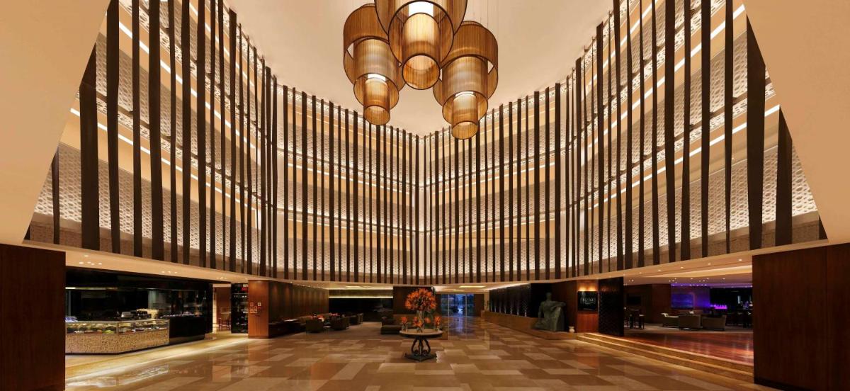 a large lobby with a large chandelier in a building at Hilton Bangalore Embassy GolfLinks in Bengaluru
