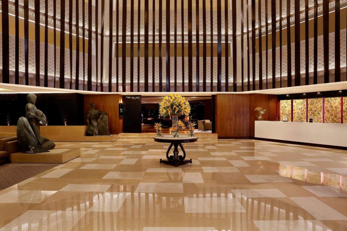 a lobby with a table in the middle of a building at Hilton Bangalore Embassy GolfLinks in Bengaluru