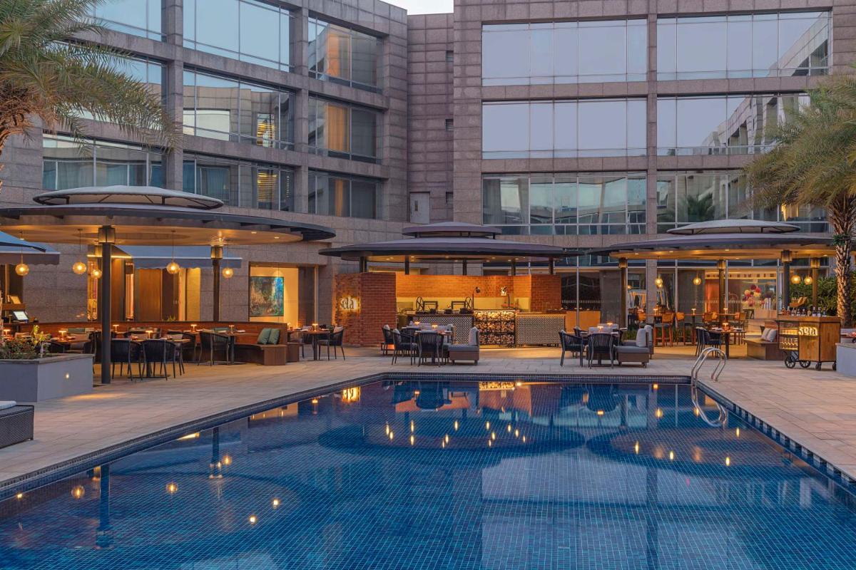 a swimming pool in front of a building at Hilton Bangalore Embassy GolfLinks in Bengaluru