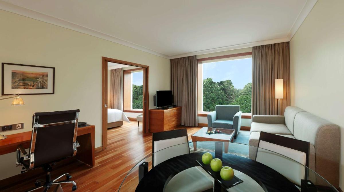 a living room with a couch and a television at Hilton Bangalore Embassy GolfLinks in Bengaluru