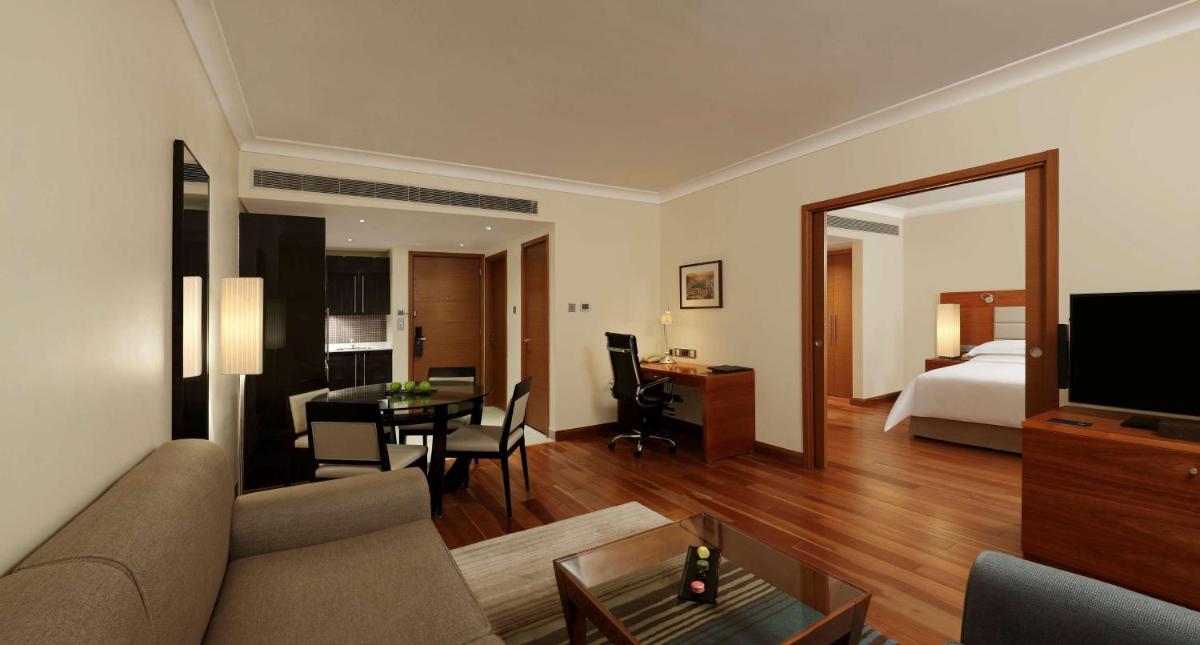 a living room with a couch and a bedroom at Hilton Bangalore Embassy GolfLinks in Bengaluru