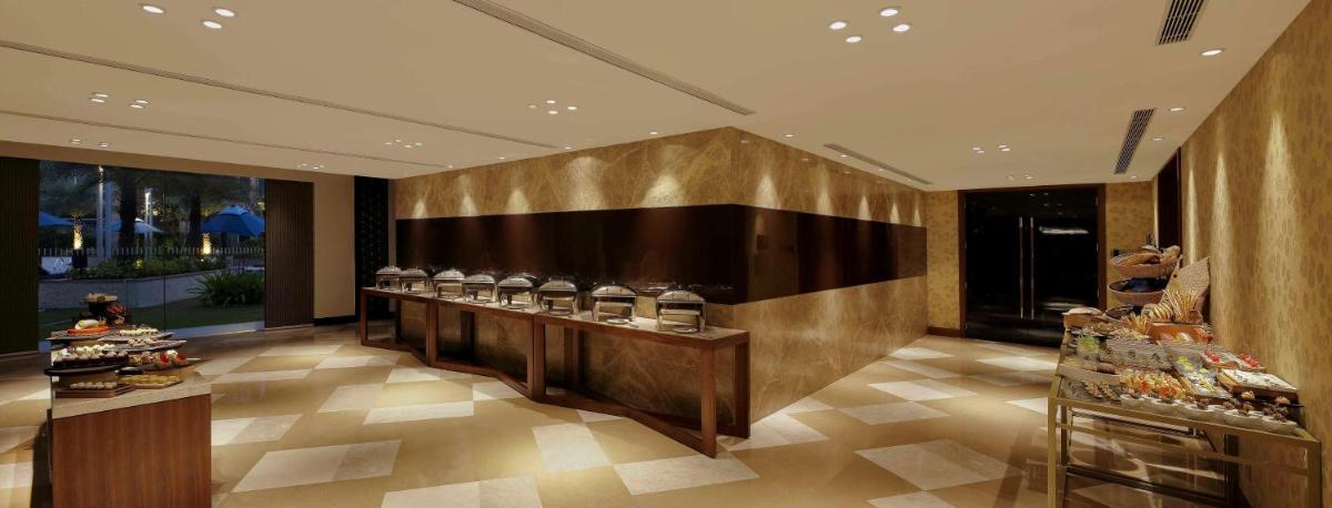 a lobby with a counter with glasses of wine at Hilton Bangalore Embassy GolfLinks in Bengaluru