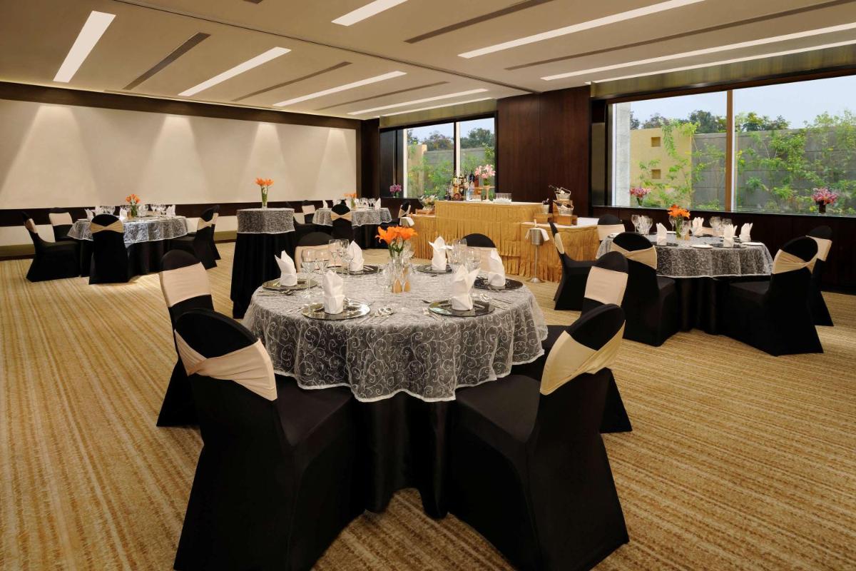 a conference room with tables and chairs and tablesktop at Hilton Bangalore Embassy GolfLinks in Bengaluru