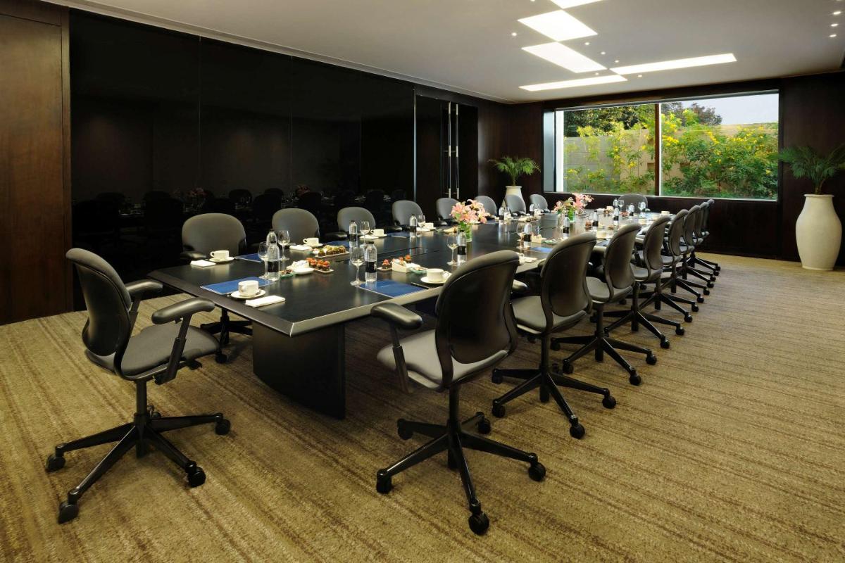 a large conference room with a long table and chairs at Hilton Bangalore Embassy GolfLinks in Bengaluru