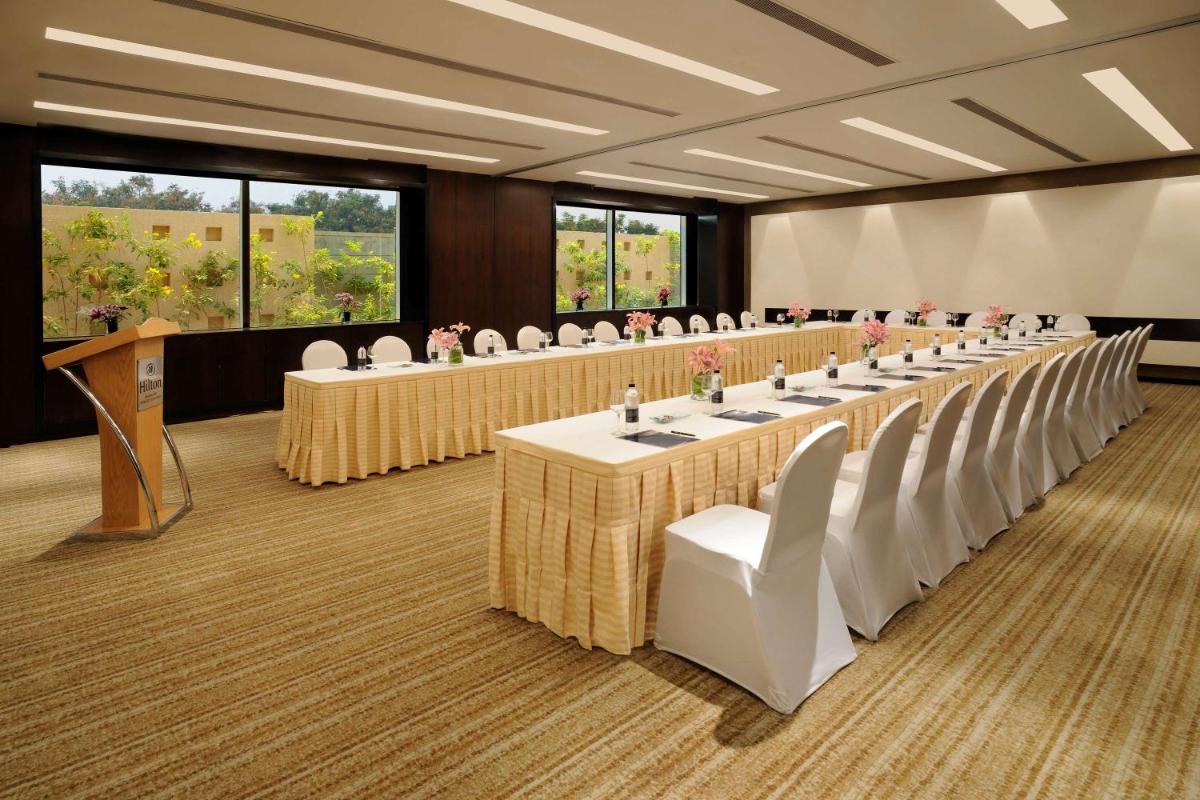 a row of tables and chairs in a room at Hilton Bangalore Embassy GolfLinks in Bengaluru