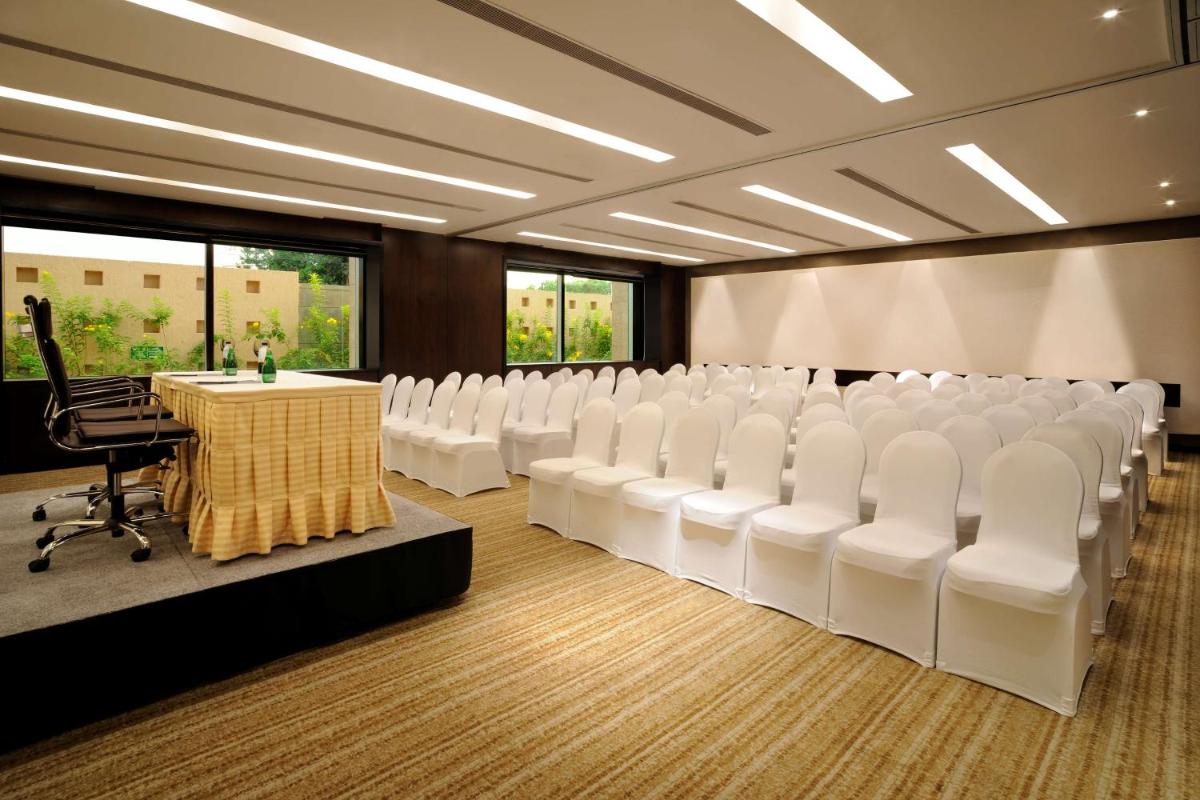 a conference room with white chairs and a table at Hilton Bangalore Embassy GolfLinks in Bengaluru