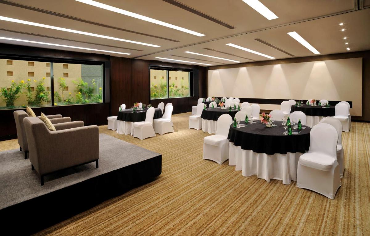 a conference room with tables and white chairs at Hilton Bangalore Embassy GolfLinks in Bengaluru