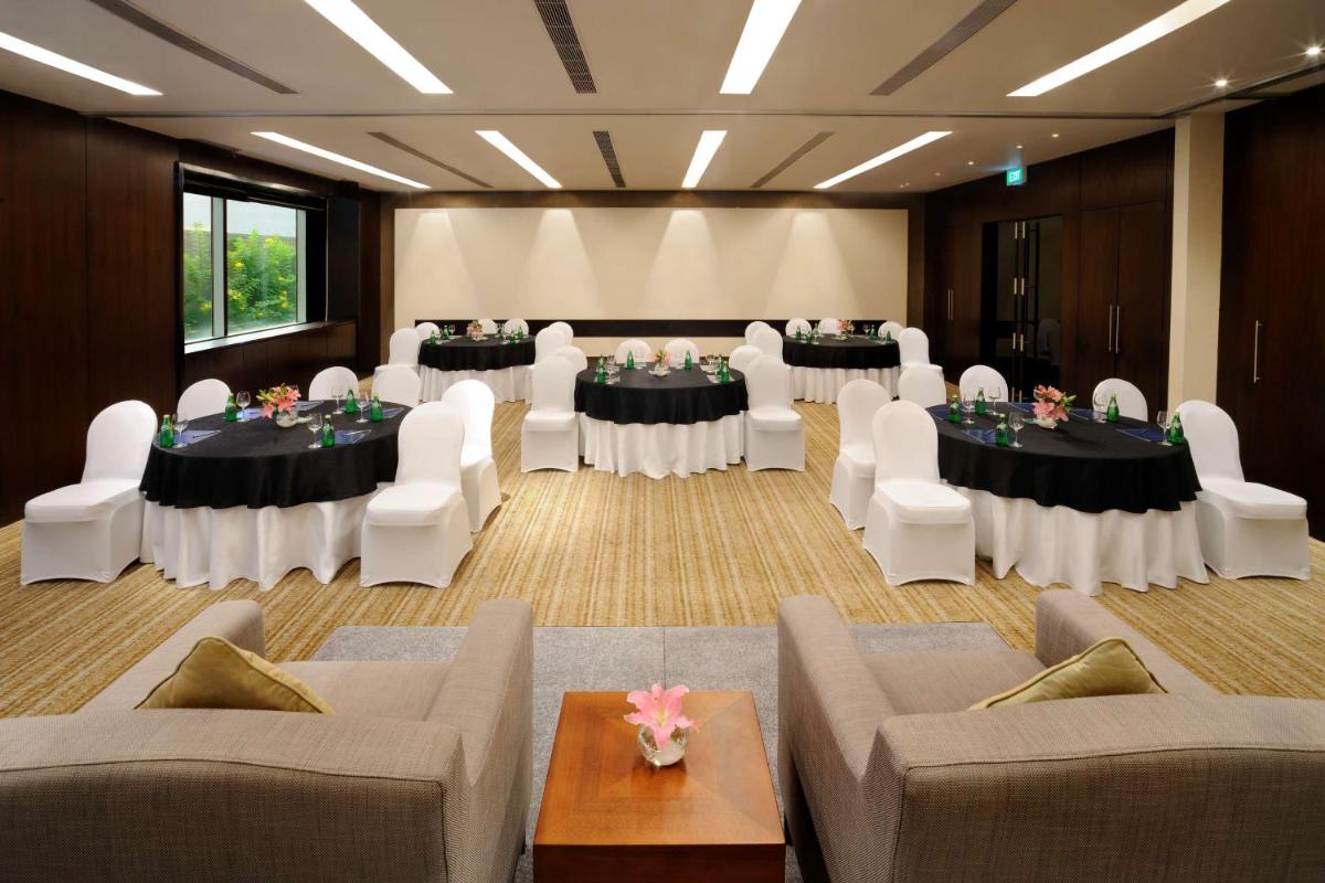 a large room with tables and chairs and a room with tables and chairs at Hilton Bangalore Embassy GolfLinks in Bengaluru +88 photos