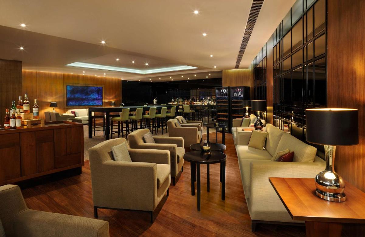 a lobby with couches and a bar in a hotel at Hilton Bangalore Embassy GolfLinks in Bengaluru