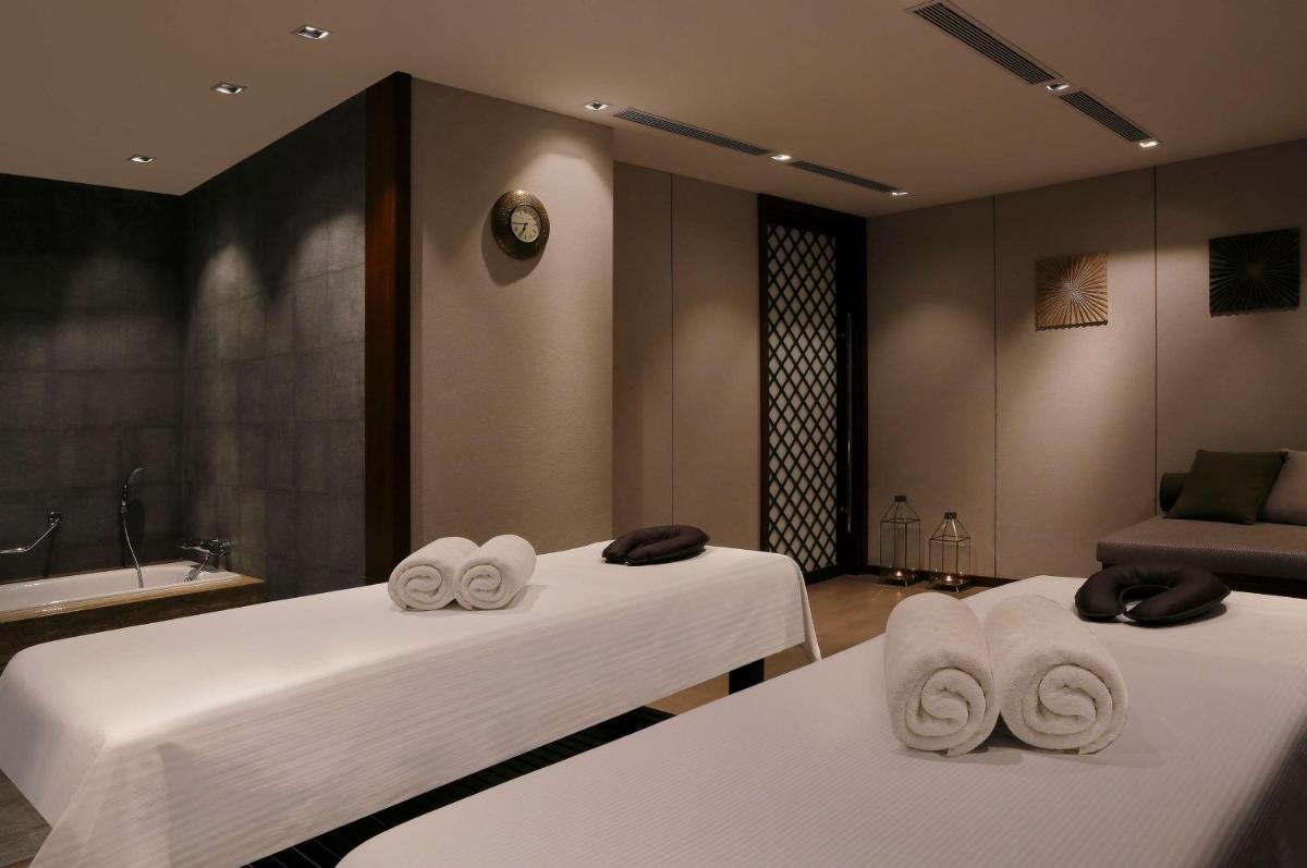 two beds with towels on them in a room at Hilton Bangalore Embassy GolfLinks in Bengaluru
