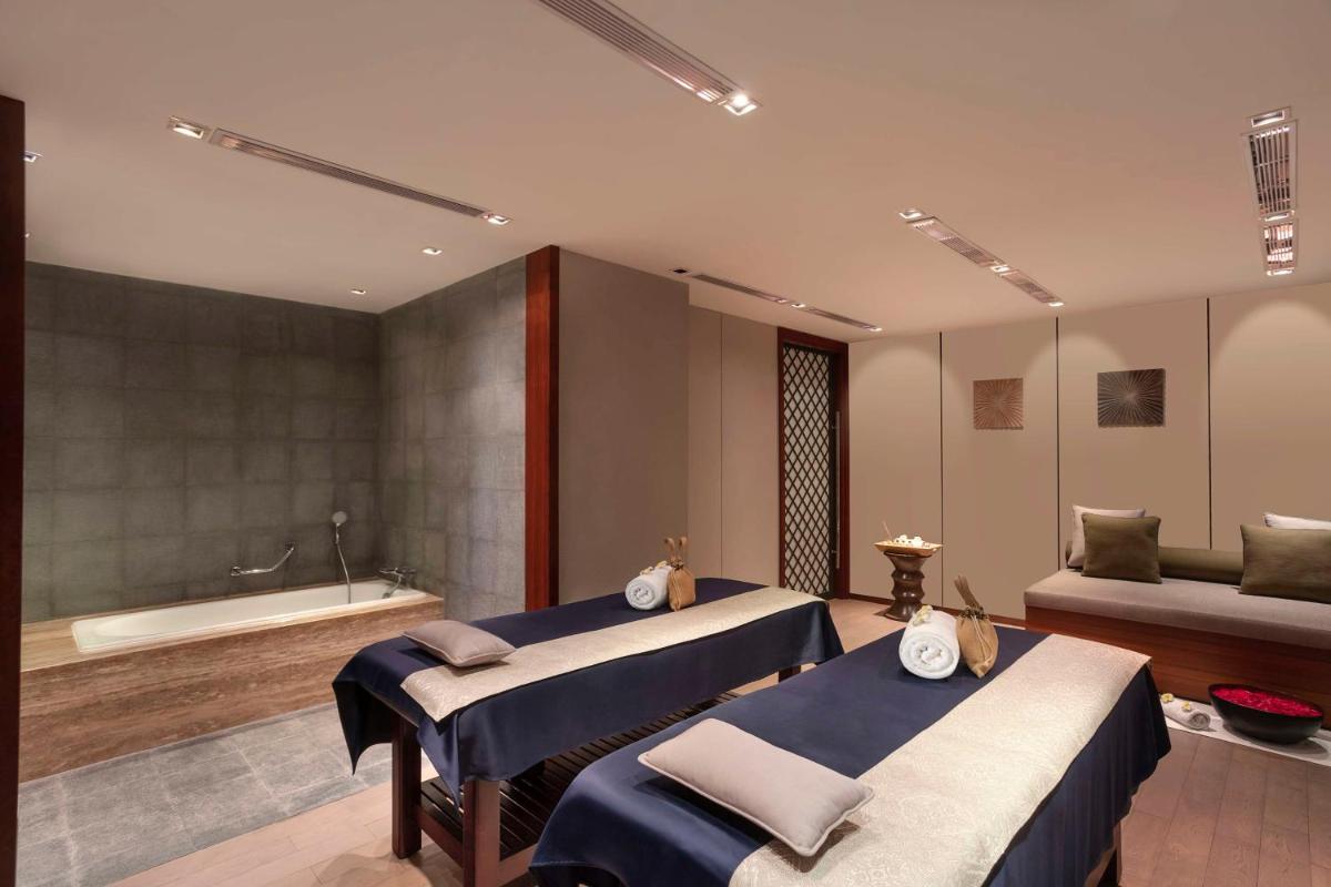a bathroom with two beds and a bath tub at Hilton Bangalore Embassy GolfLinks in Bengaluru