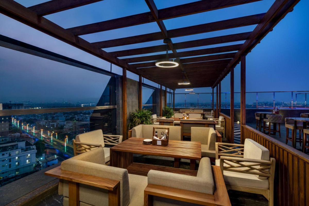 a balcony with tables and chairs on a building at Hilton Jaipur in Jaipur a balcony with tables and chairs on a building at Hilton Jaipur in Jaipur