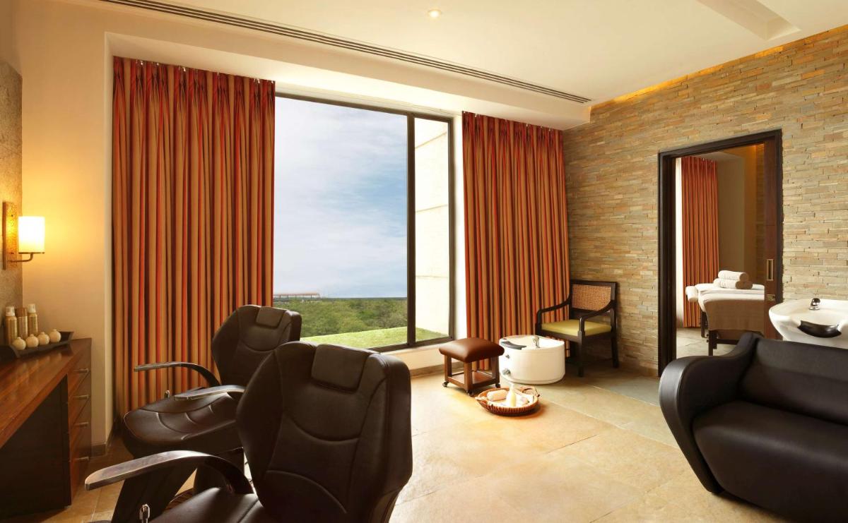 a living room with chairs and a large window at Hilton Jaipur in Jaipur a living room with chairs and a large window at Hilton Jaipur in Jaipur