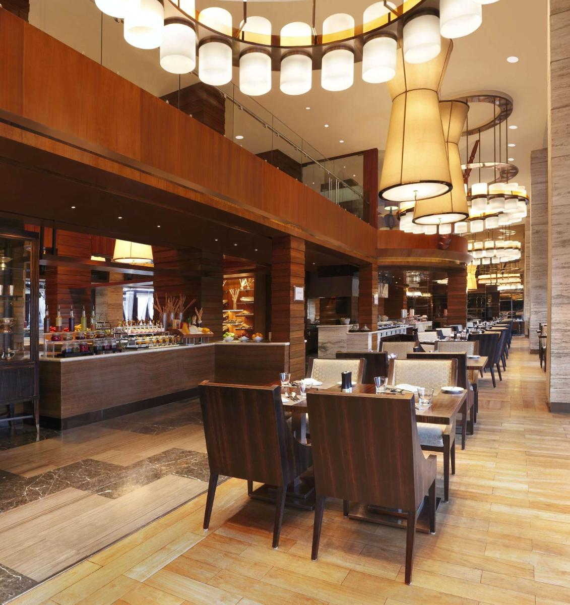 a restaurant with tables and chairs and a bar at Hilton Chennai in Chennai