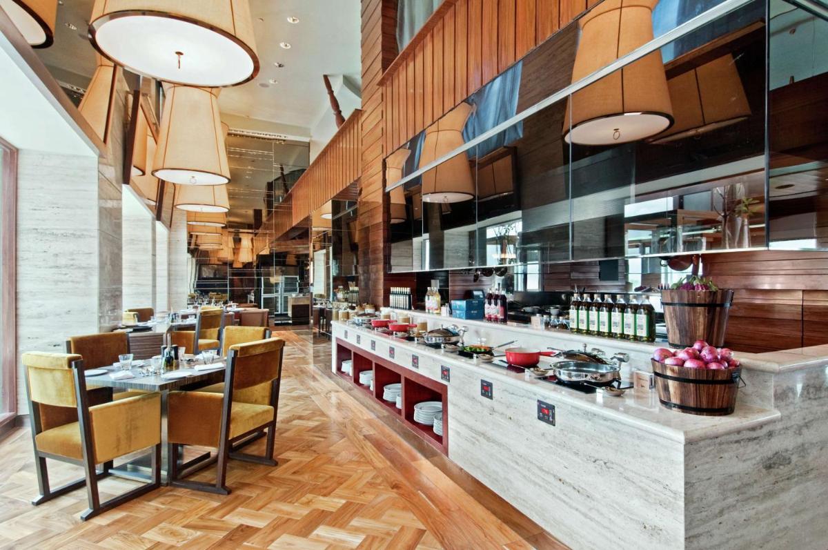 a restaurant with a bar with chairs and tables at Hilton Chennai in Chennai