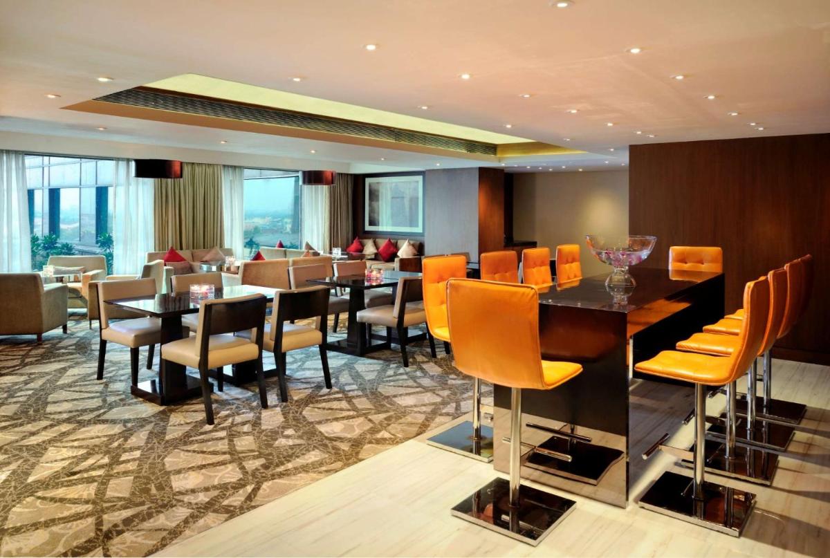 a restaurant with a long table and chairs in a room at Hilton Chennai in Chennai +62 photos
