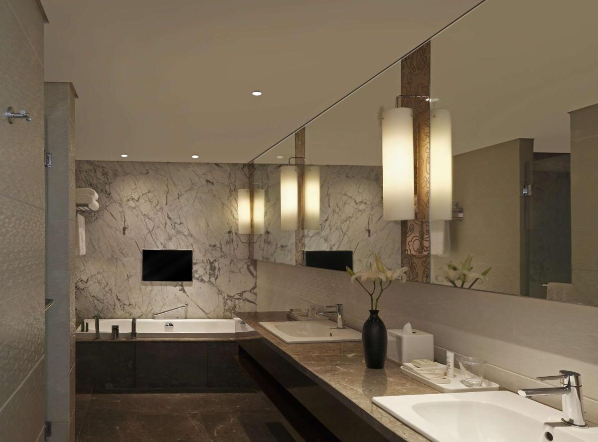 a bathroom with two sinks and a large mirror at Hilton Chennai in Chennai