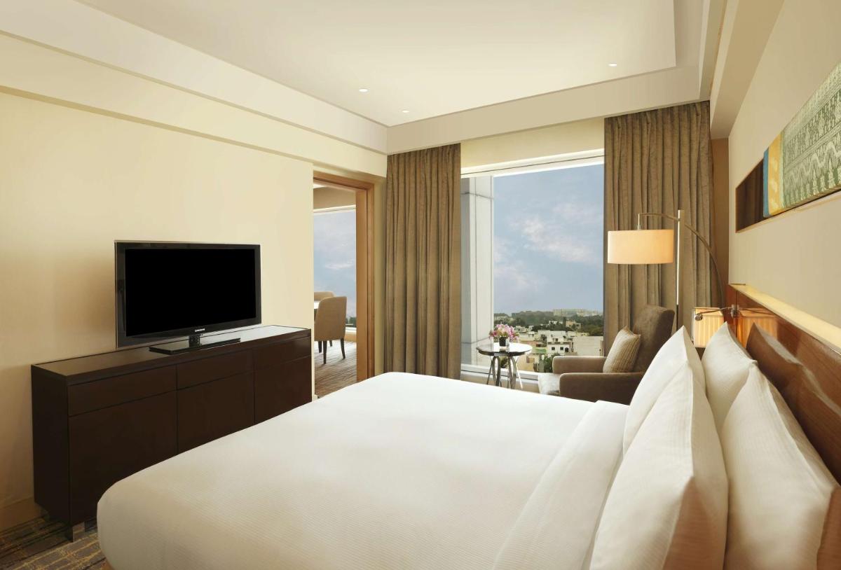 a hotel room with a bed and a television at Hilton Chennai in Chennai