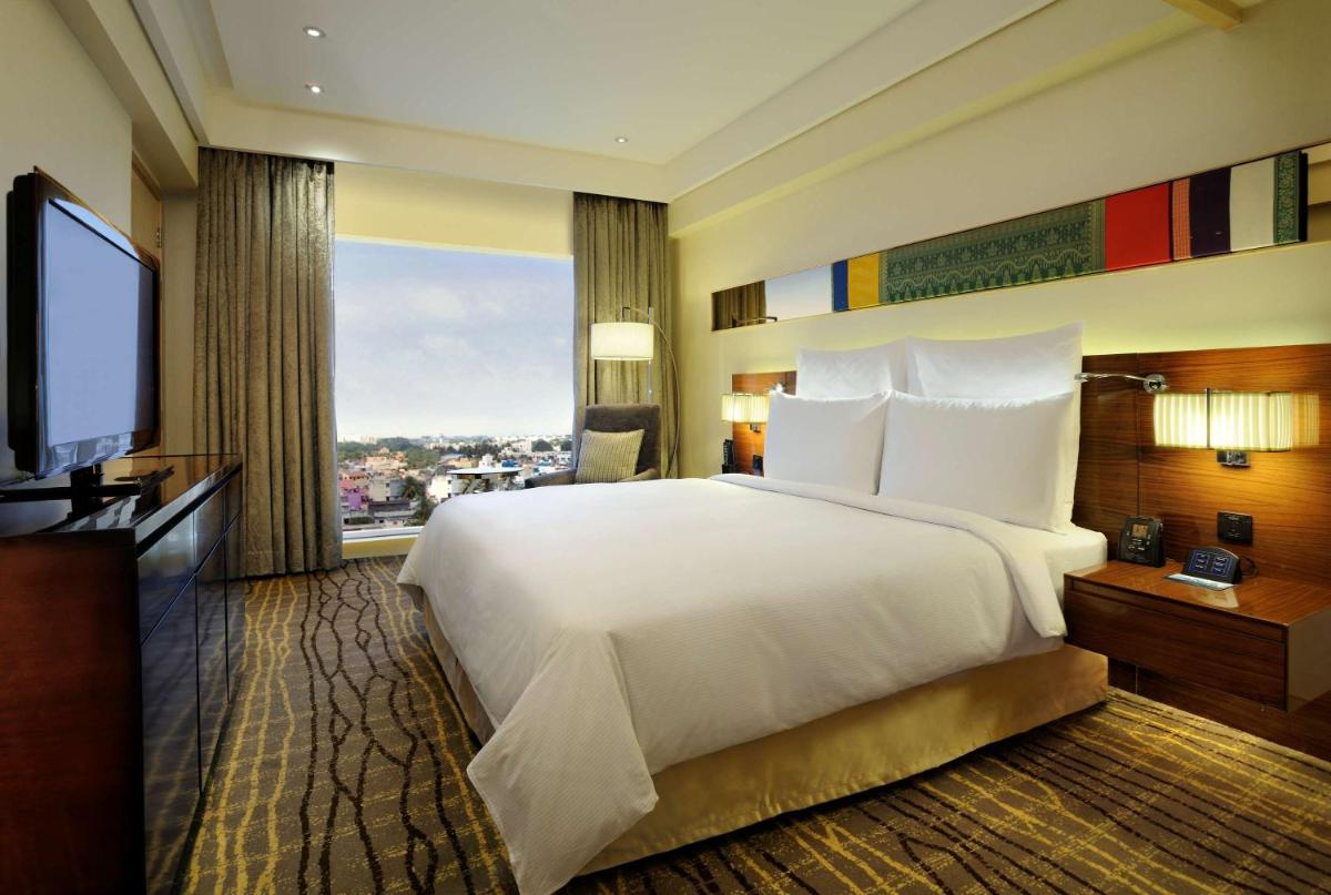 a bedroom with a large white bed and a large window at Hilton Chennai in Chennai