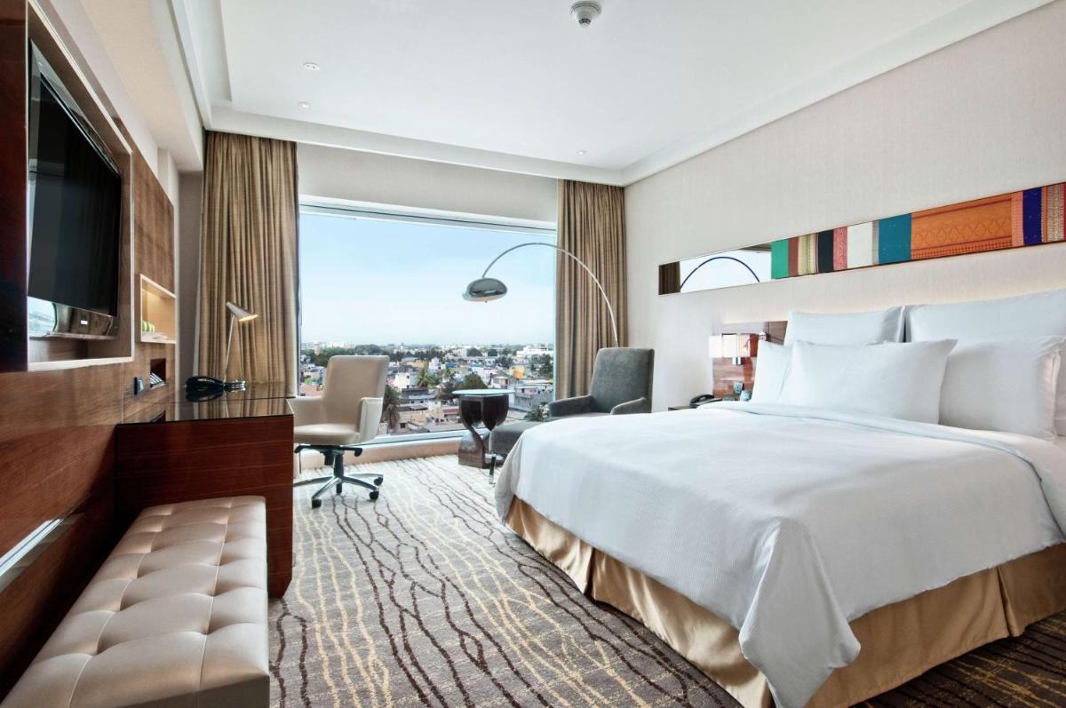 a hotel room with a large bed and a window at Hilton Chennai in Chennai