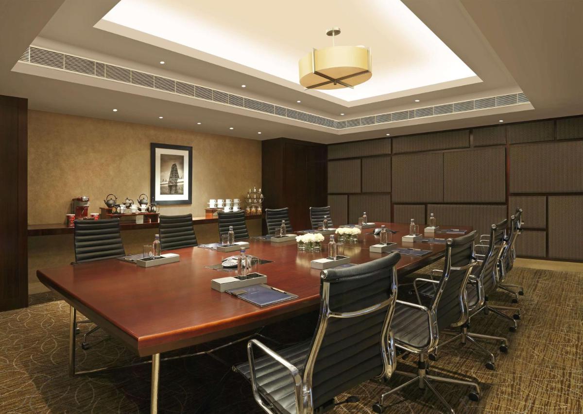 a large conference room with a large wooden table and chairs at Hilton Chennai in Chennai