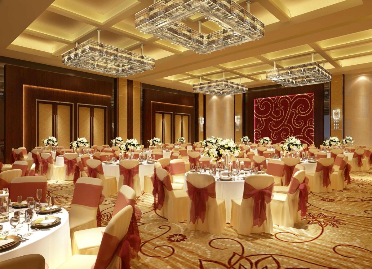 a banquet hall with white tables and chairs at Hilton Chennai in Chennai