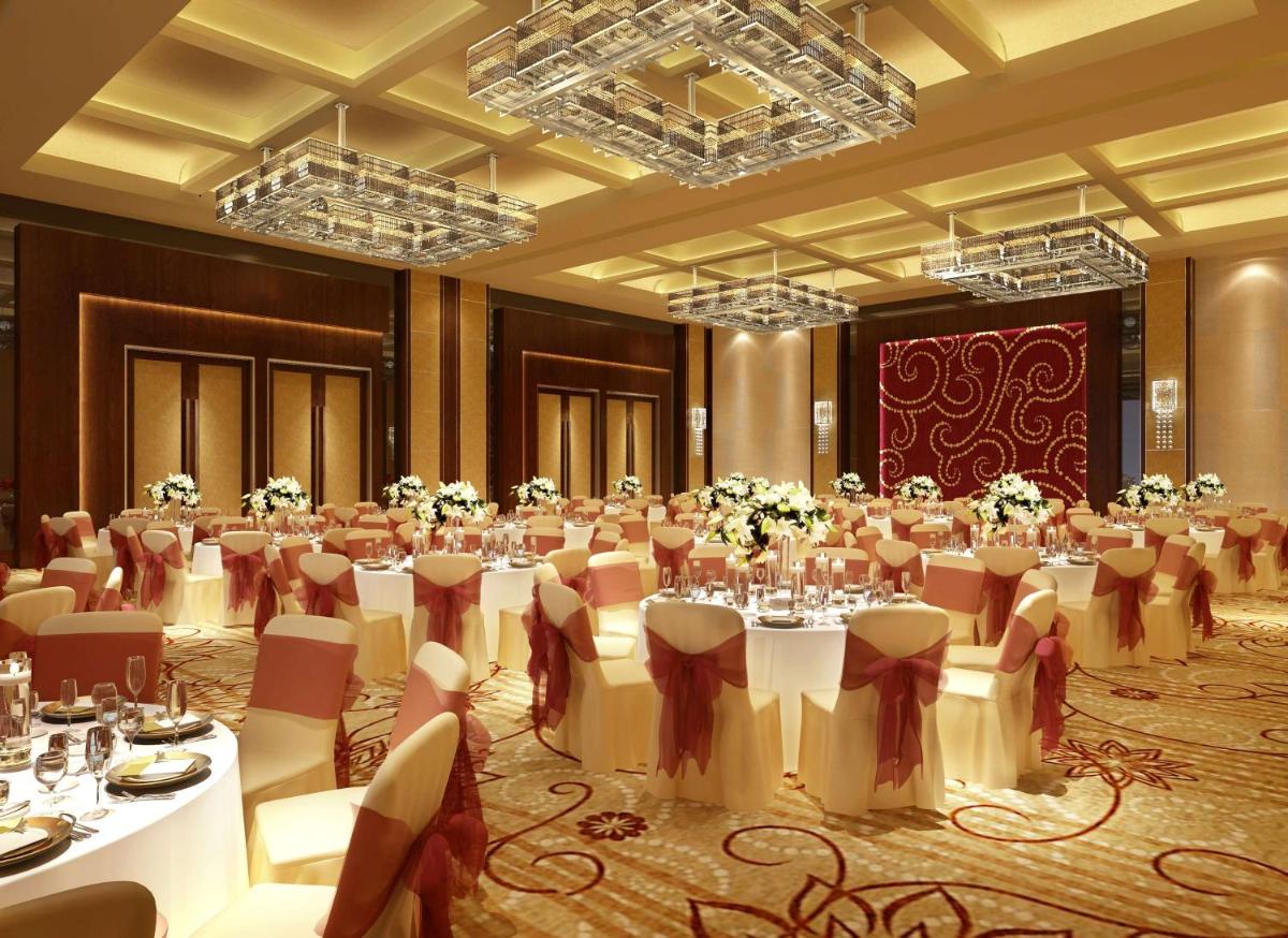 a banquet hall with white tables and chairs at Hilton Chennai in Chennai