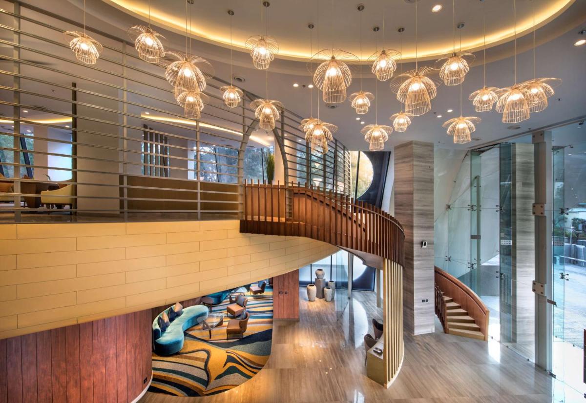 a spiral staircase in a lobby with chandeliers at DoubleTree by Hilton Ahmedabad in Ahmedabad