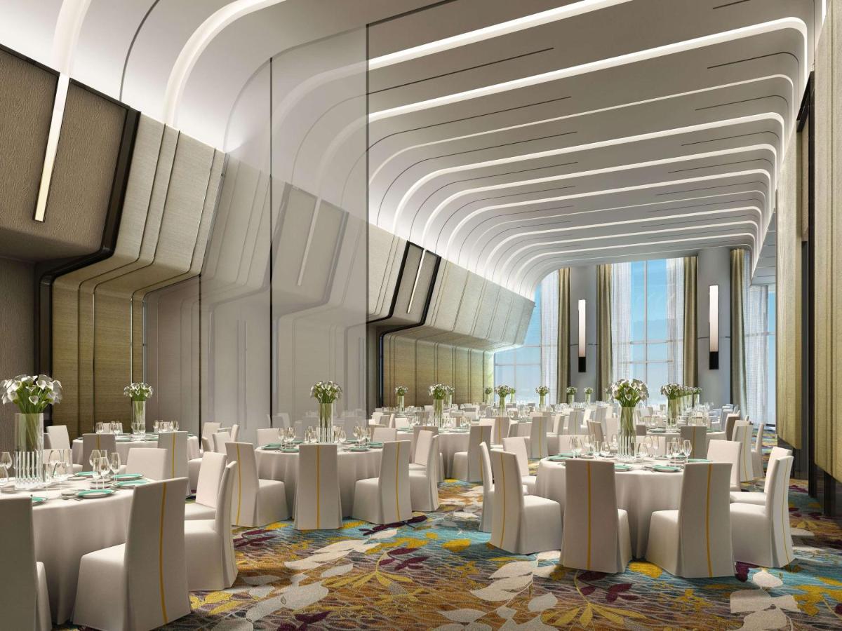 a banquet hall with white tables and white chairs at DoubleTree by Hilton Ahmedabad in Ahmedabad