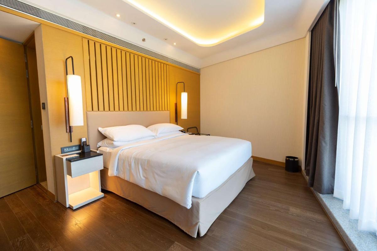 a bedroom with a white bed and a yellow wall at DoubleTree by Hilton Ahmedabad in Ahmedabad +19 photos