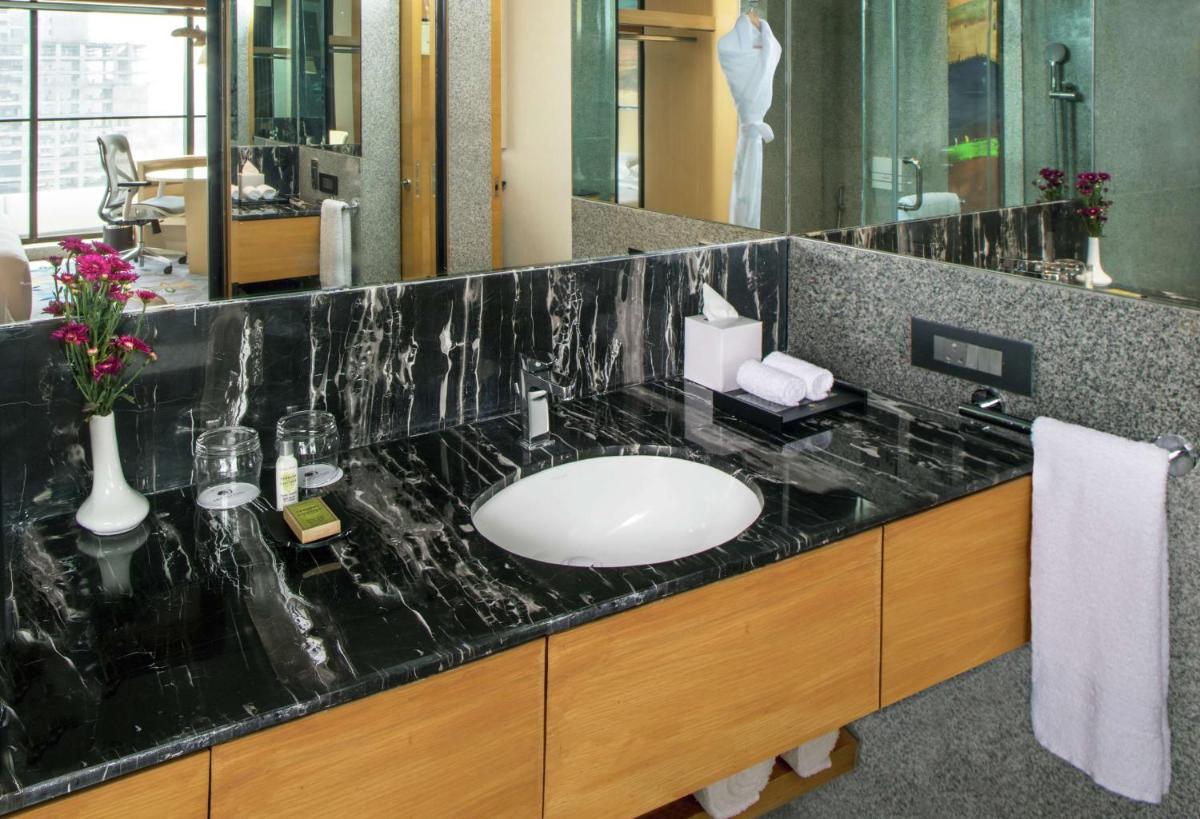 a bathroom with a sink with a black counter top at DoubleTree by Hilton Ahmedabad in Ahmedabad