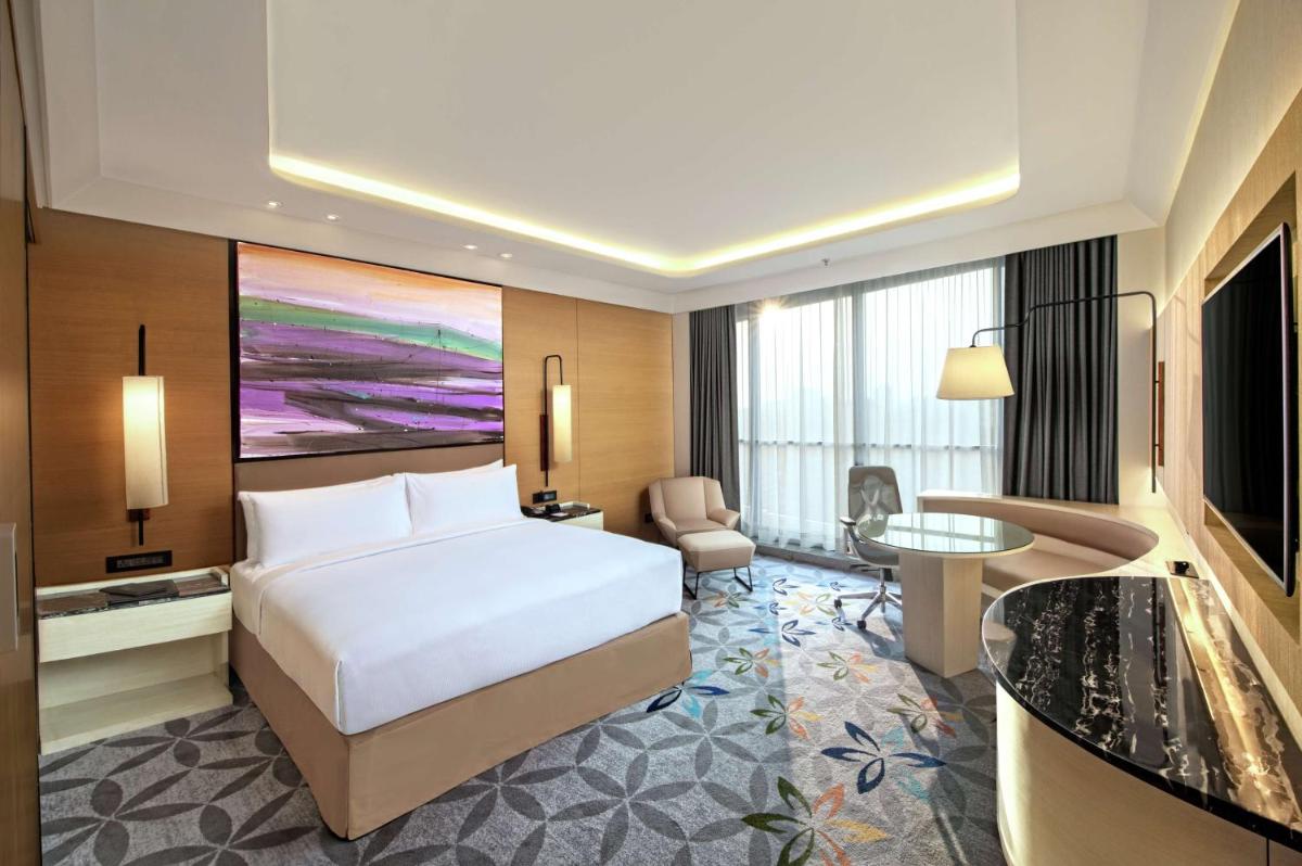 a hotel room with a bed and a desk at DoubleTree by Hilton Ahmedabad in Ahmedabad