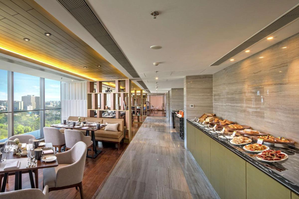 a restaurant with a buffet line with plates of food at DoubleTree by Hilton Ahmedabad in Ahmedabad