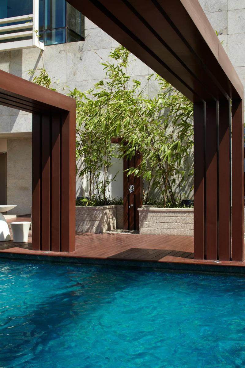 a swimming pool next to a building at Park Hyatt Hotel and Residences, Hyderabad in Hyderabad