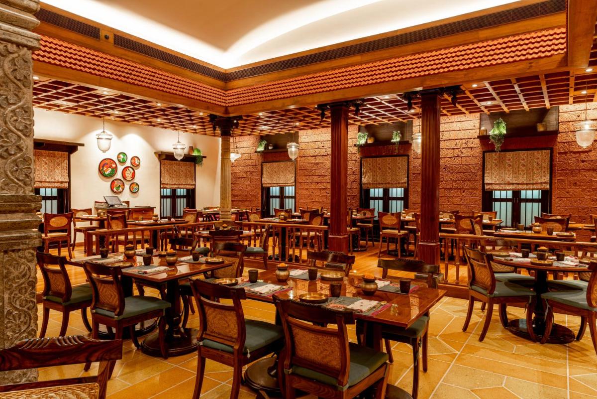 a restaurant with wooden tables and chairs in a room at President - IHCL SeleQtions in Mumbai