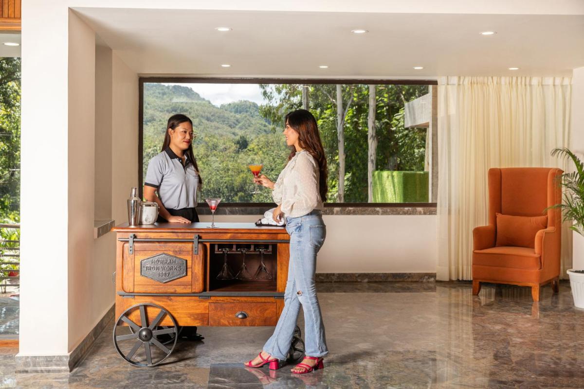 two women standing at a bar with a drink at The Prominence Mussoorie Road Dehradun in Dehradun