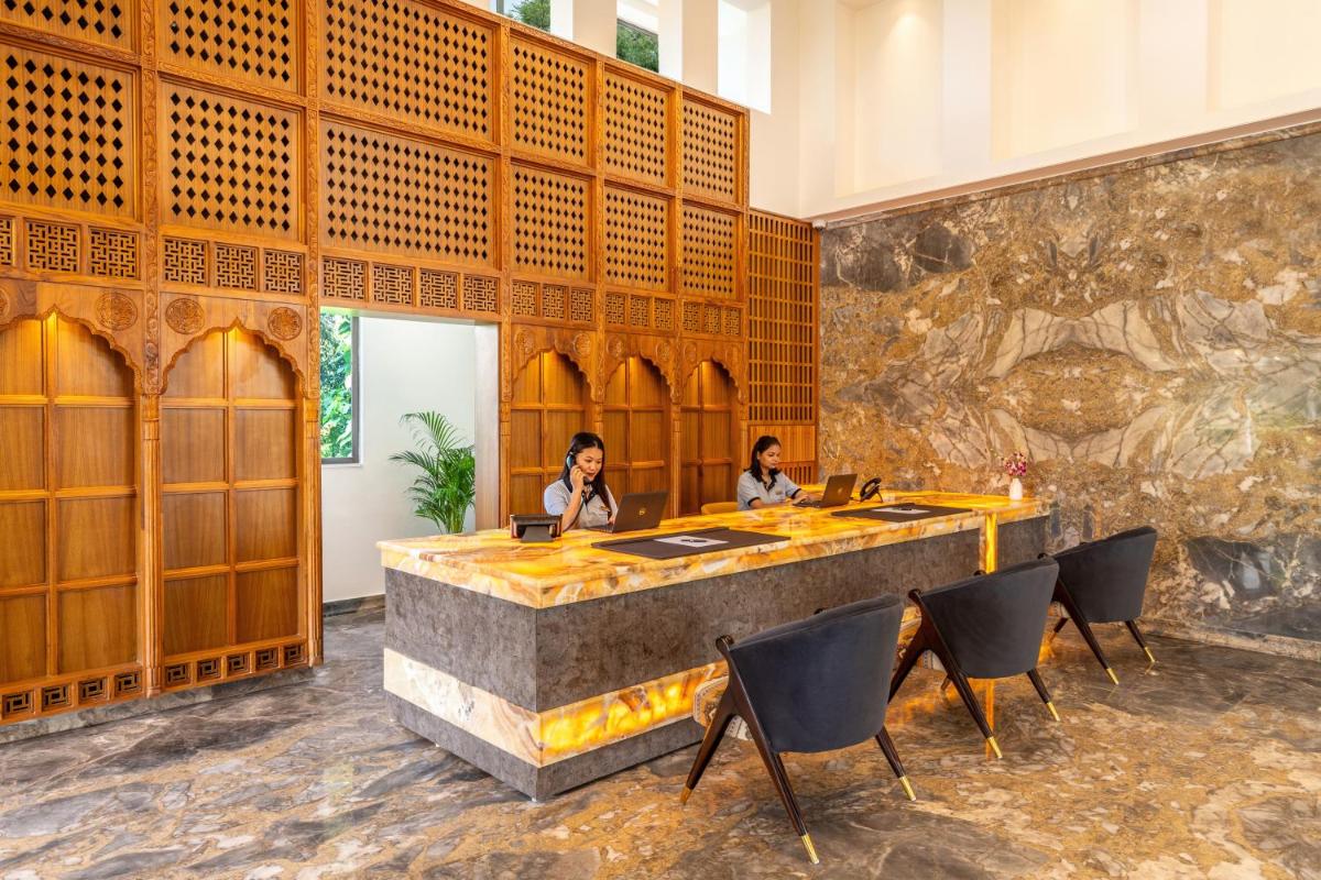 two women sitting at a table in a room with a stone wall at The Prominence Mussoorie Road Dehradun in Dehradun