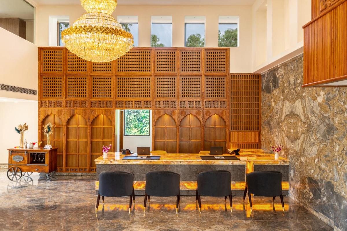 a large room with a bar with chairs and a chandelier at The Prominence Mussoorie Road Dehradun in Dehradun