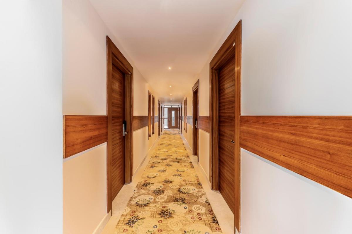 a hallway with wood paneling and a rug on the floor at The Prominence Mussoorie Road Dehradun in Dehradun