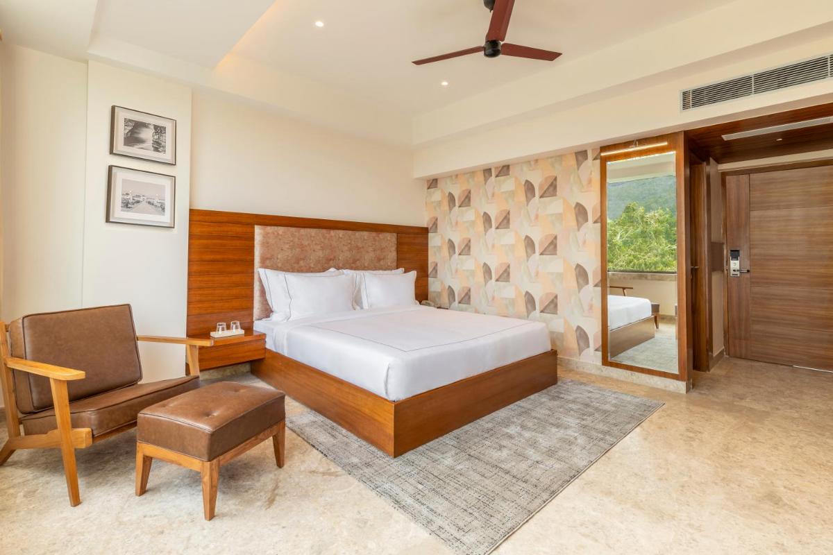 a bedroom with a bed and a desk and a chair at The Prominence Mussoorie Road Dehradun in Dehradun