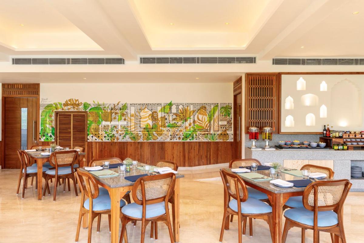 a restaurant with tables and chairs and a kitchen at The Prominence Mussoorie Road Dehradun in Dehradun