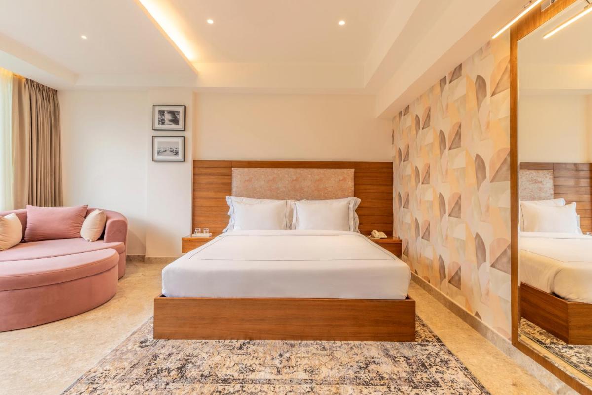 a hotel room with a bed and a couch at The Prominence Mussoorie Road Dehradun in Dehradun