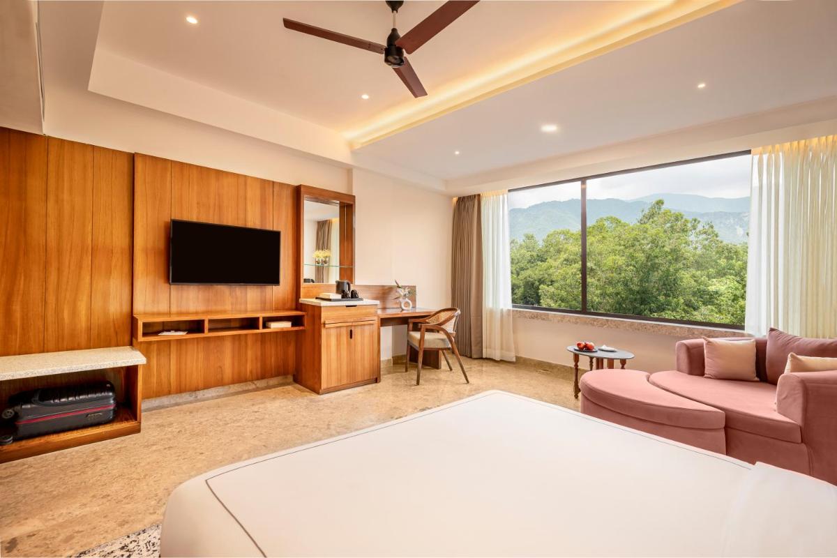 a living room with a couch and a tv at The Prominence Mussoorie Road Dehradun in Dehradun