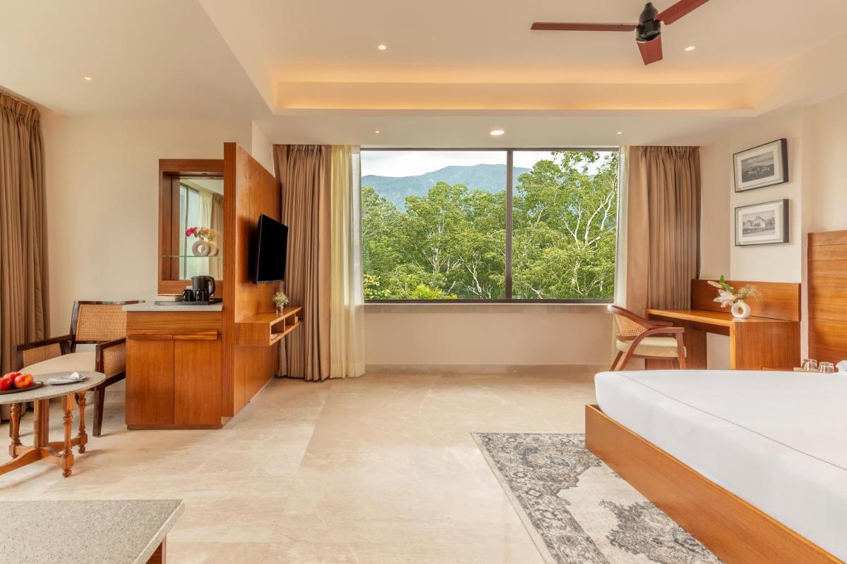 a hotel room with a bed and a large window at The Prominence Mussoorie Road Dehradun in Dehradun