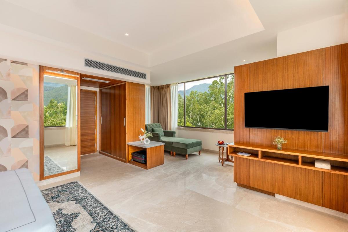 a living room with a television on a wall at The Prominence Mussoorie Road Dehradun in Dehradun