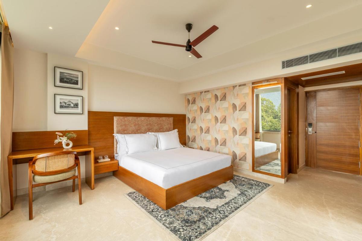a bedroom with a bed and a desk and a window at The Prominence Mussoorie Road Dehradun in Dehradun +62 photos